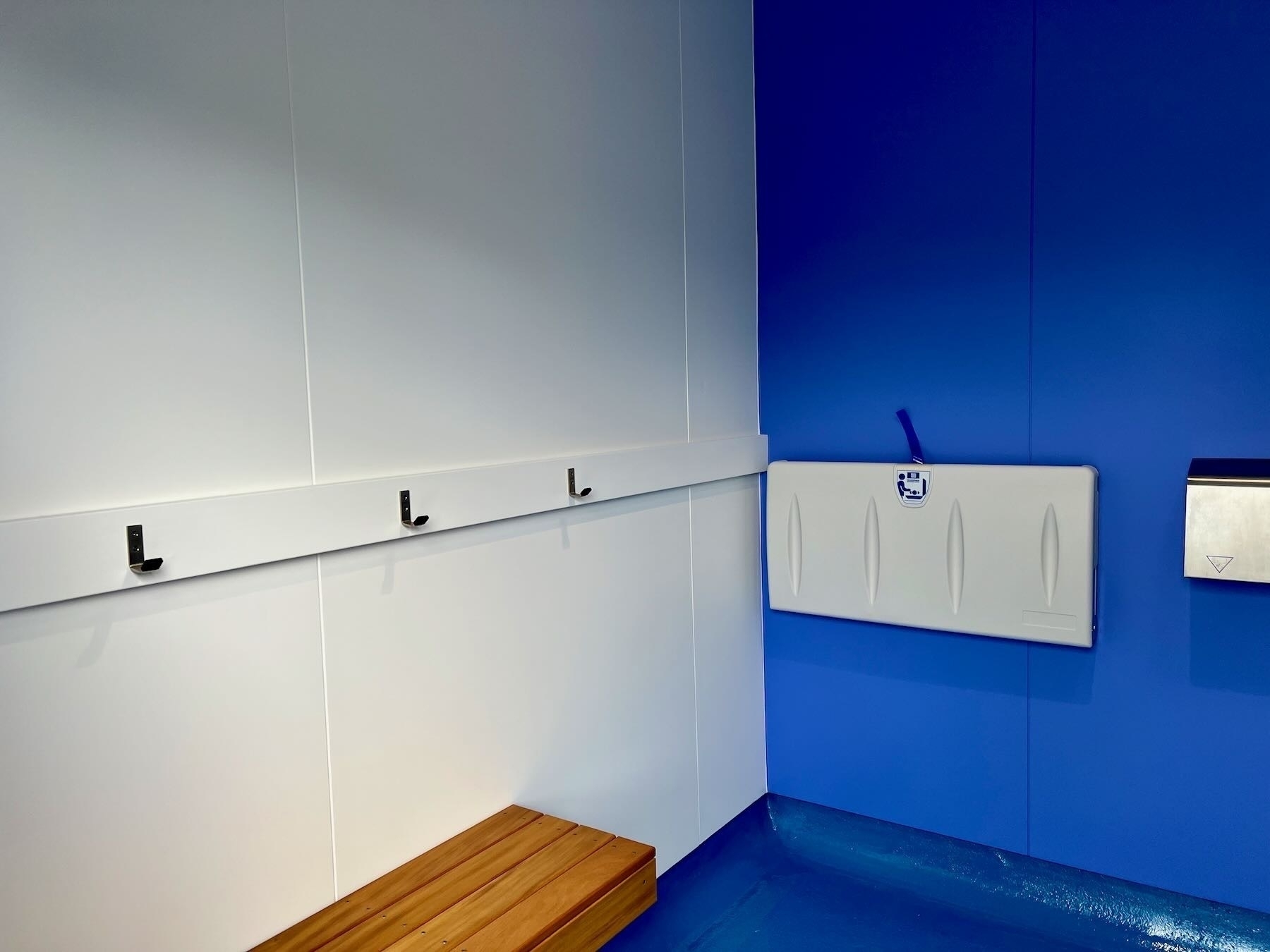 Toilet cubicle showing baby change table and coat hooks. 